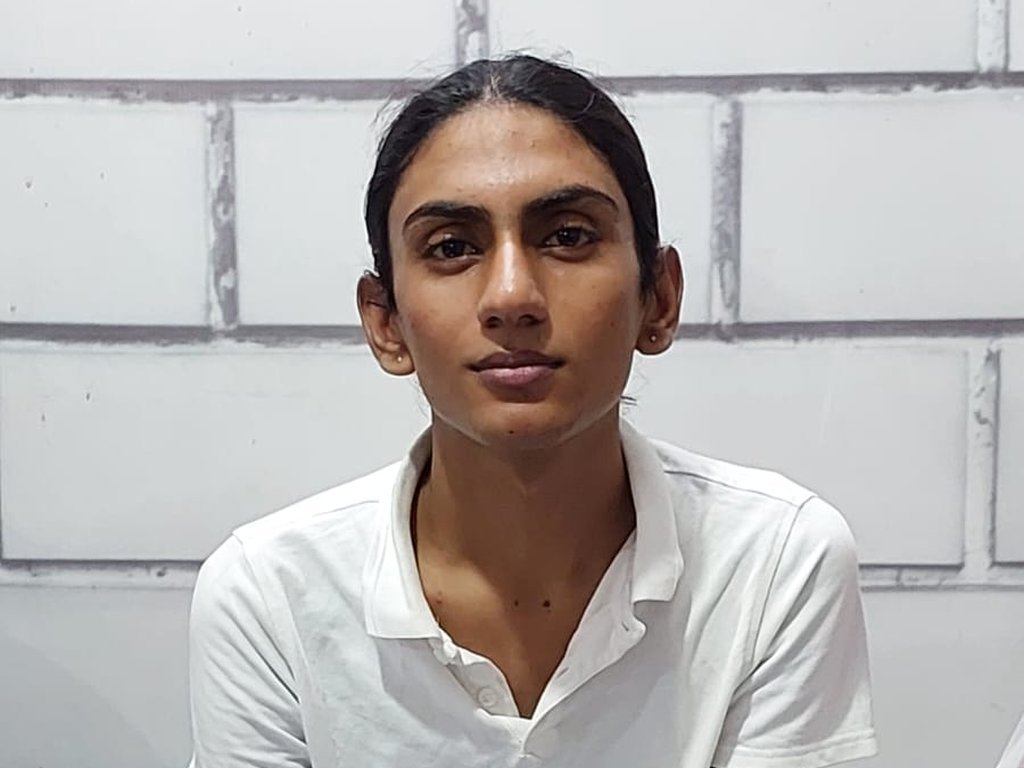A participant in a white shirt holding survey papers at a Degardis session
