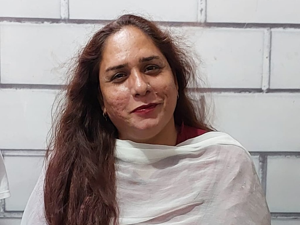 A smiling participant in a maroon outfit and white dupatta at a Degardis session