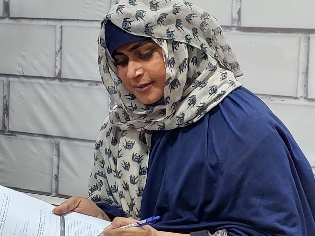 A participant in a headscarf completing a survey at a Degardis session