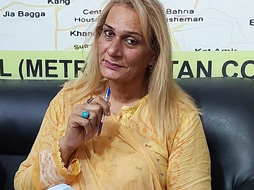 A participant in a yellow outfit holding notes and a pen at a Degardis session