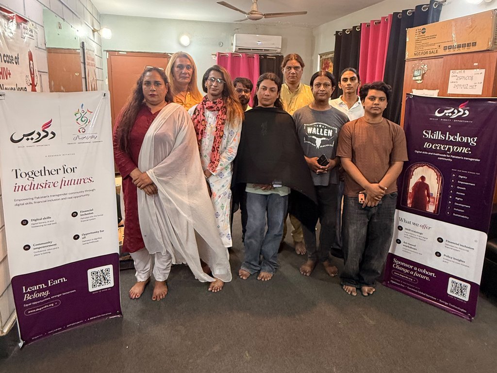 Degardis participants and team standing together between Degardis banners at a community session in Lahore